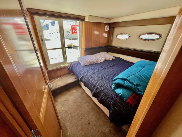  Yacht Photos Pics Cozy bedroom in 2001 Carver 404 yacht with porthole windows and bedding.