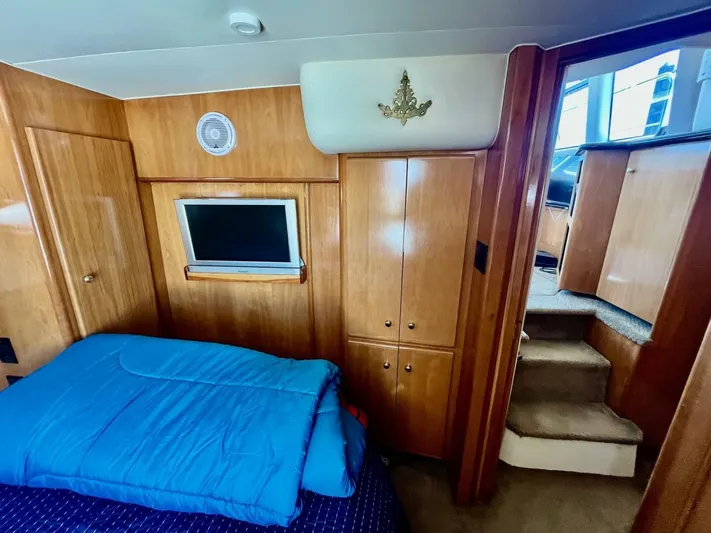  Yacht Photos Pics Interior of 2001 Carver 404 yacht with wood paneling and blue bedding.