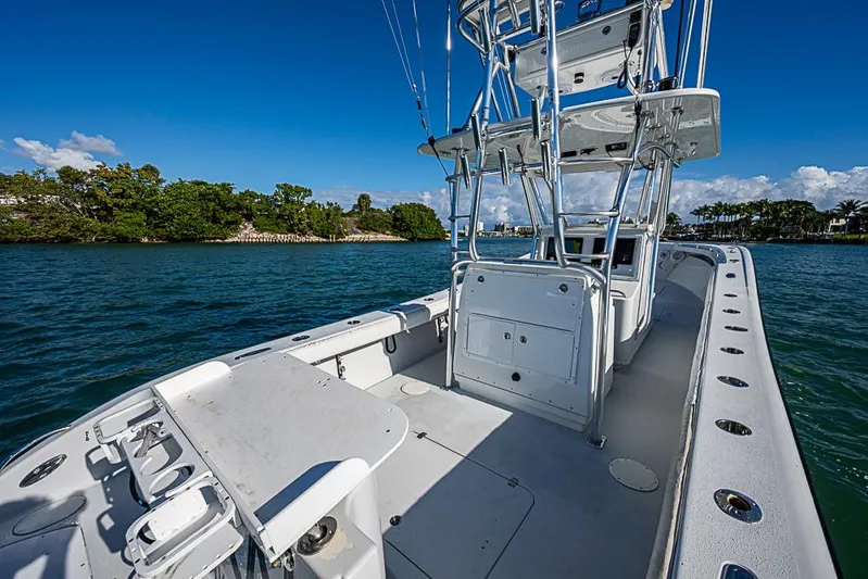  Yacht Photos Pics 2002 Yellowfin 36 Offshore boat on water, clear sky, lush shoreline in background.