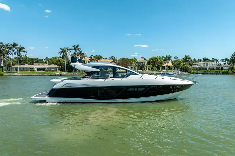 Midnight Oil Yacht Photos Pics 2018 Sunseeker Predator 57 yacht cruising on a sunny day near luxury waterfront homes.