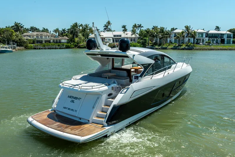 Midnight Oil Yacht Photos Pics 2018 Sunseeker Predator 57 yacht cruising on a sunny day near luxury waterfront homes.