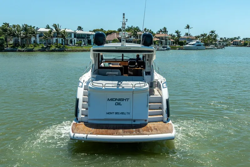 Midnight Oil Yacht Photos Pics 2018 Sunseeker Predator 57 yacht cruising on a sunny day near waterfront homes.