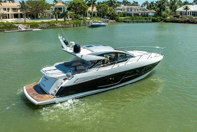 Midnight Oil Yacht Photos Pics 2018 Sunseeker Predator 57 yacht cruising in a scenic waterfront setting.