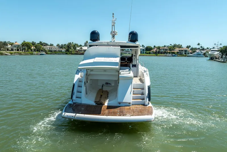Midnight Oil Yacht Photos Pics 2018 Sunseeker Predator 57 yacht cruising on a sunny day in a scenic waterfront area.