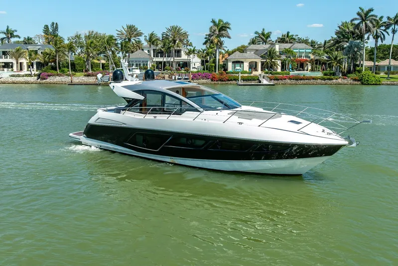 Midnight Oil Yacht Photos Pics 2018 Sunseeker Predator 57 yacht cruising on a scenic waterway with luxury homes.