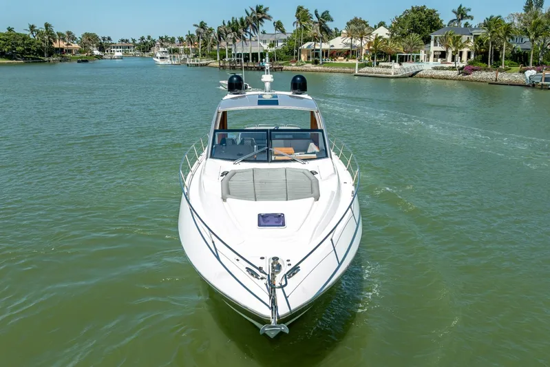 Midnight Oil Yacht Photos Pics 2018 Sunseeker Predator 57 yacht cruising in a scenic waterfront area.