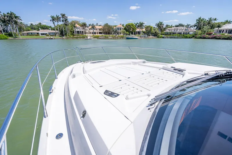 Midnight Oil Yacht Photos Pics 2018 Sunseeker Predator 57 yacht cruising on a scenic waterway with luxury homes.