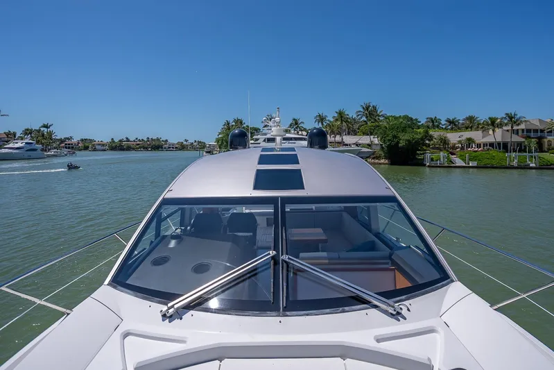 Midnight Oil Yacht Photos Pics 2018 Sunseeker Predator 57 yacht cruising on a sunny day in a scenic waterway.