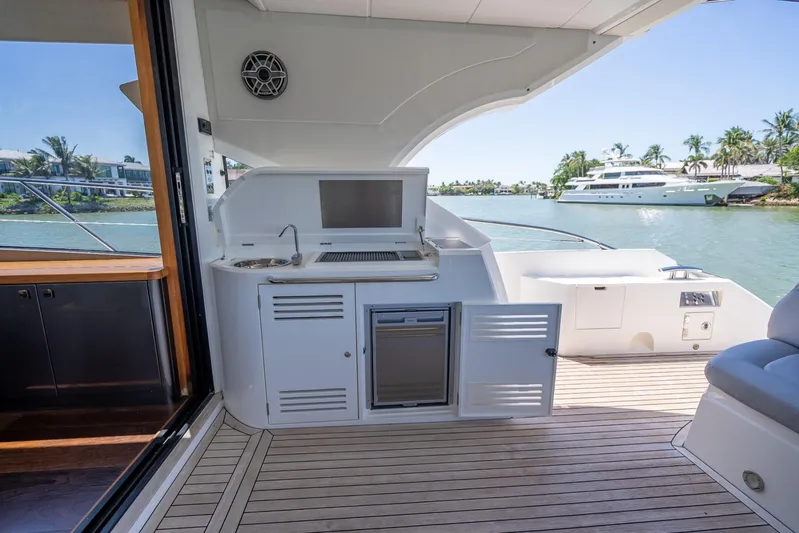 Midnight Oil Yacht Photos Pics 2018 Sunseeker Predator 57 yacht deck with outdoor kitchen and scenic water view.