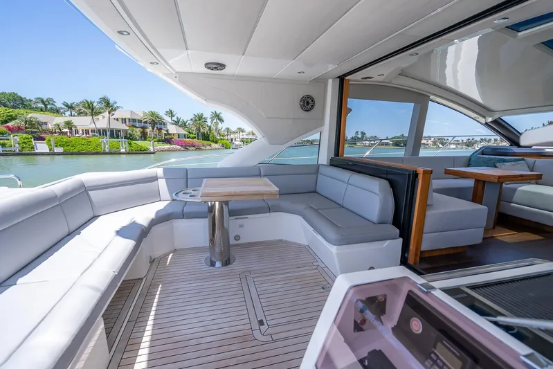 Midnight Oil Yacht Photos Pics Luxurious 2018 Sunseeker Predator 57 yacht with spacious outdoor seating and scenic waterfront view.