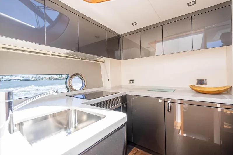 Midnight Oil Yacht Photos Pics Modern kitchen interior of 2018 Sunseeker Predator 57 yacht with sleek cabinetry and ocean view.