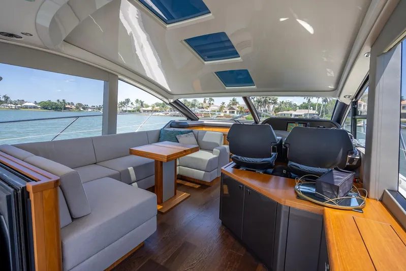 Midnight Oil Yacht Photos Pics Luxurious interior of 2018 Sunseeker Predator 57 yacht with modern seating and panoramic windows.