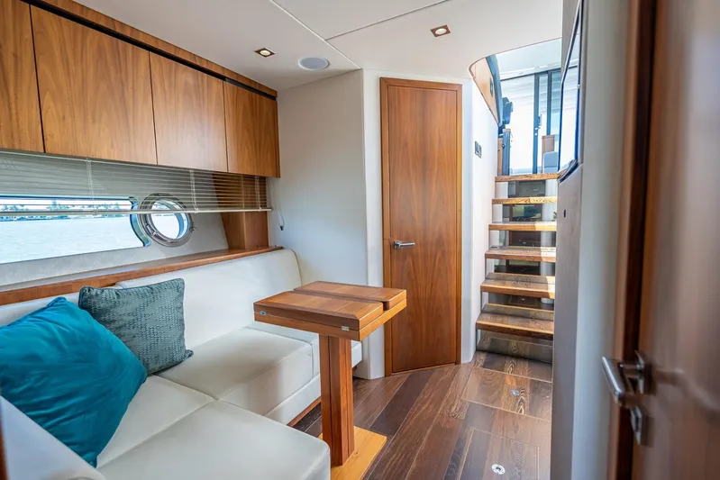 Midnight Oil Yacht Photos Pics Luxurious interior of 2018 Sunseeker Predator 57 yacht with wooden accents and cozy seating.