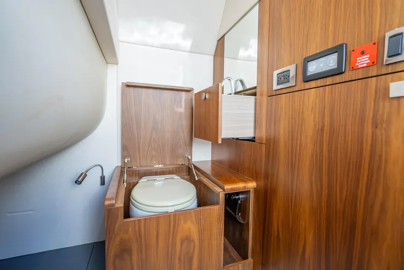 Midnight Oil Yacht Photos Pics 2018 Sunseeker Predator 57 yacht bathroom with wooden cabinetry and modern fixtures.