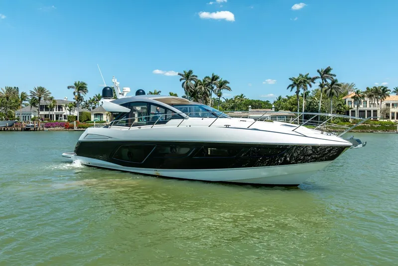 Midnight Oil Yacht Photos Pics 2018 Sunseeker Predator 57 yacht cruising on a sunny day near luxury waterfront homes.