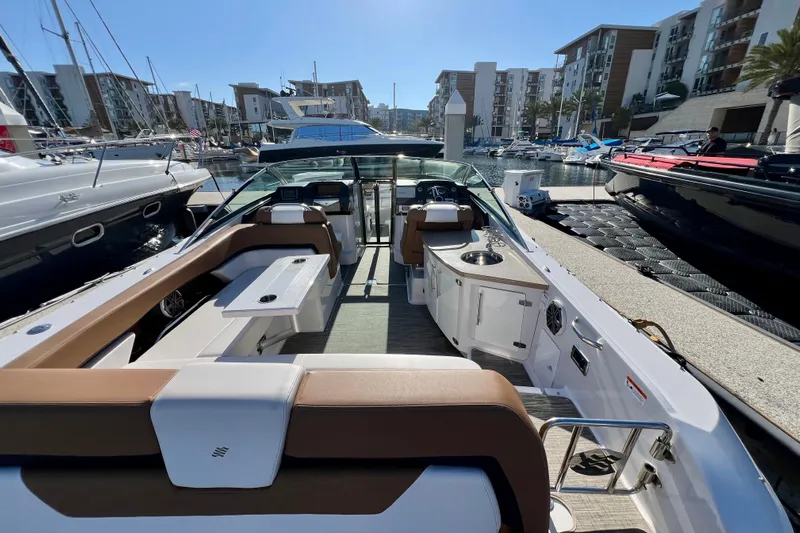  Yacht Photos Pics 2019 Four Winns Horizon H290 boat interior at marina, featuring seating and kitchenette.