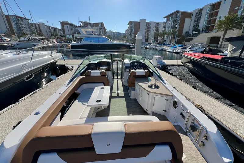  Yacht Photos Pics 2019 Four Winns Horizon H290 boat interior at marina, featuring seating and helm.