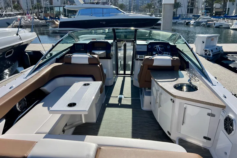  Yacht Photos Pics 2019 Four Winns Horizon H290 boat interior with seating, table, and kitchenette in marina setting.