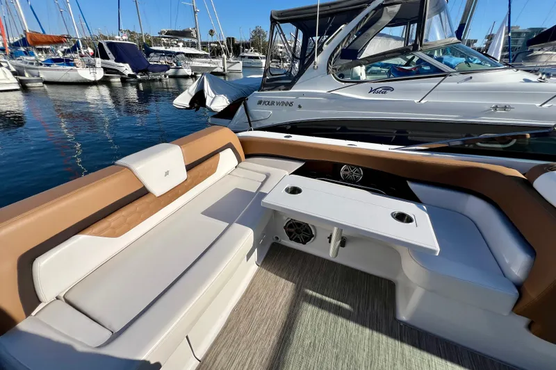  Yacht Photos Pics 2019 Four Winns Horizon H290 boat interior with seating and table in a marina.