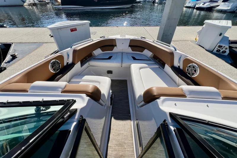  Yacht Photos Pics 2019 Four Winns Horizon H290 boat interior with brown and white seating at a marina.