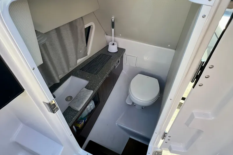  Yacht Photos Pics 2019 Four Winns Horizon H290 boat bathroom with sink, toilet, and storage.