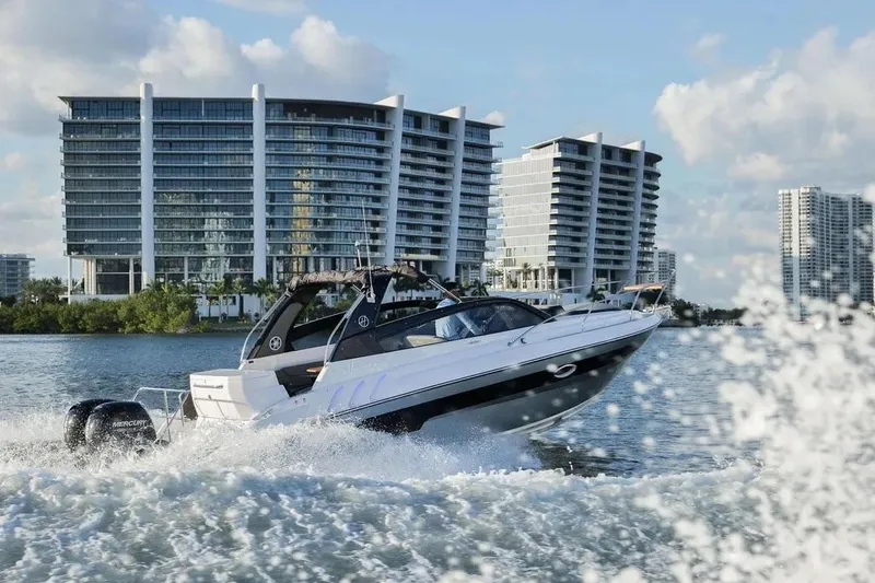  Yacht Photos Pics 2025 Hanover 305 boat cruising near modern waterfront buildings.