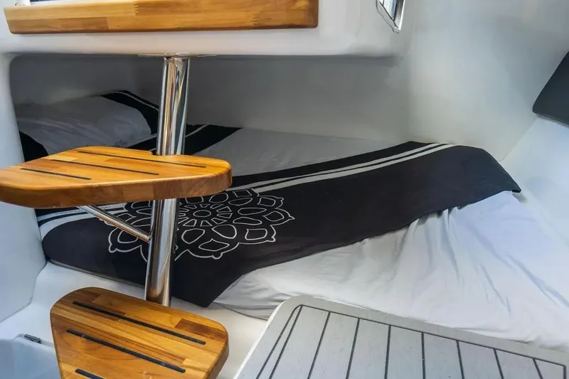  Yacht Photos Pics Cozy interior cabin of 2025 Hanover 305 boat with wooden steps and stylish bedding.