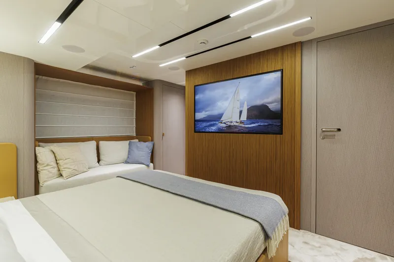  Yacht Photos Pics Luxurious interior of 2026 Cranchi Sessantadue 62 yacht with modern design and cozy bedding.