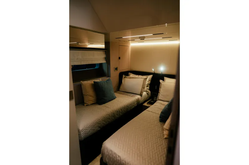  Yacht Photos Pics Luxurious twin cabin interior of 2026 Cranchi Sessantadue 62 yacht, featuring elegant bedding and ambient lighting.