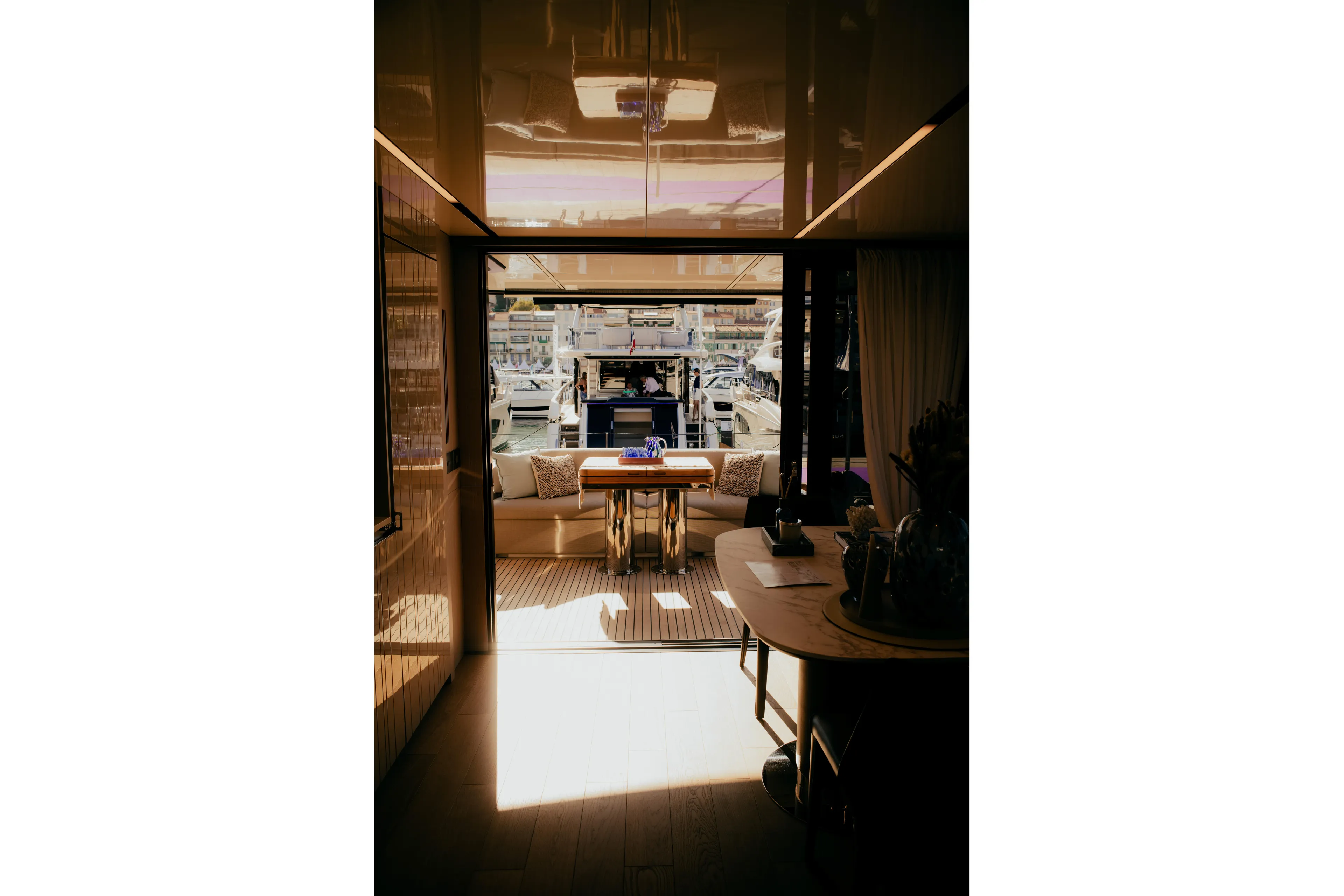  Yacht Photos Pics Interior view of 2026 Cranchi Sessantadue 62 yacht, featuring elegant dining area and marina backdrop.