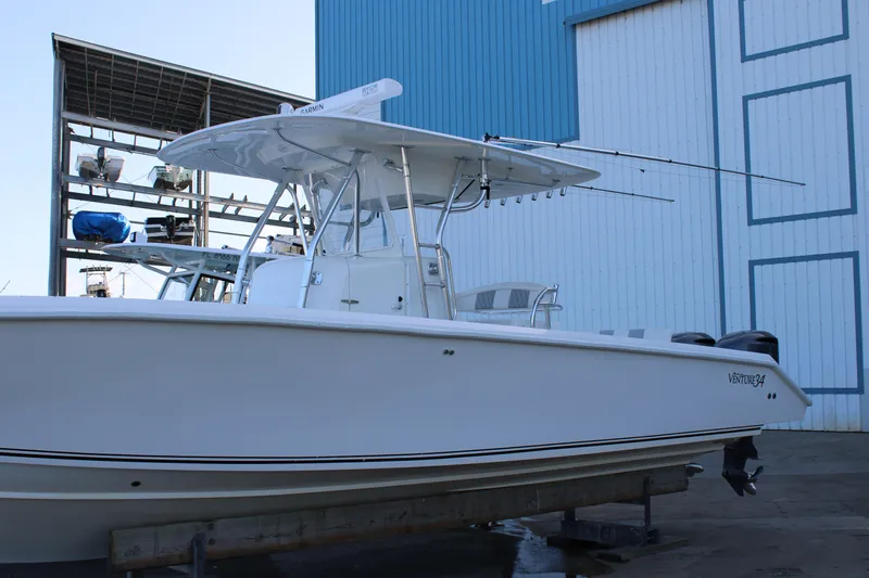 Yacht Photos Pics 1998 Venture 34 Open boat docked near a blue and white building.
