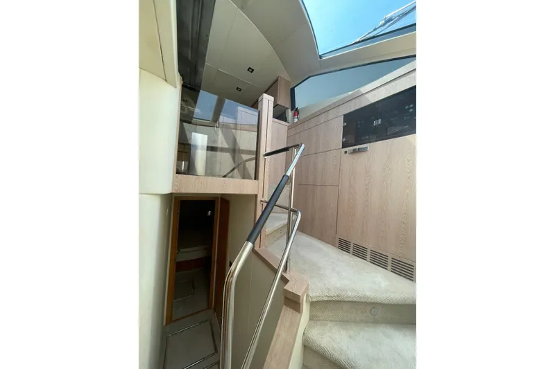  Yacht Photos Pics Interior of 2012 Sunseeker Manhattan 70 yacht, featuring modern staircase and wood paneling.