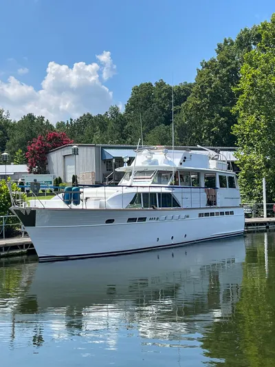  Yacht Photos Pics 1966 Chris-Craft 57 Constellation yacht docked on a sunny day, surrounded by trees.