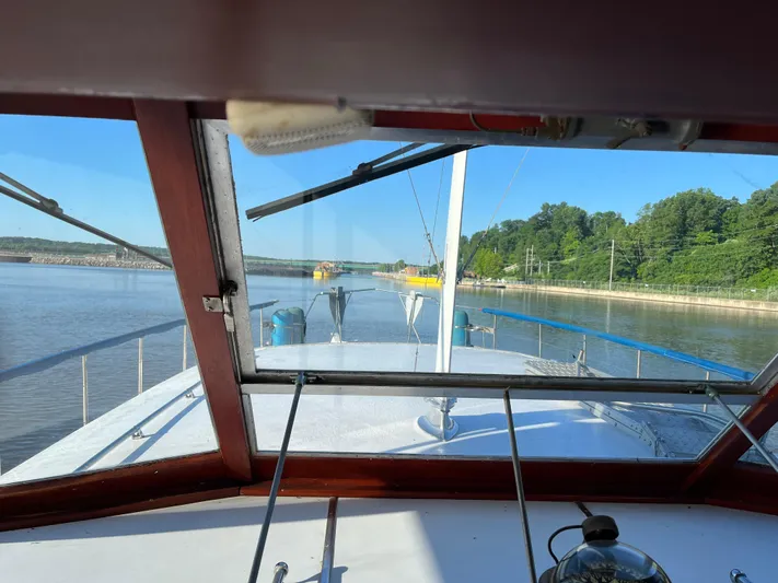  Yacht Photos Pics View from 1966 Chris-Craft 57 Constellation boat, navigating a calm river with lush greenery.