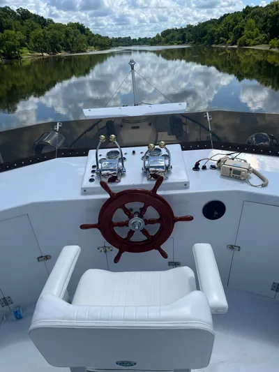  Yacht Photos Pics Captain's chair and helm of 1966 Chris-Craft 57 Constellation on a serene river.