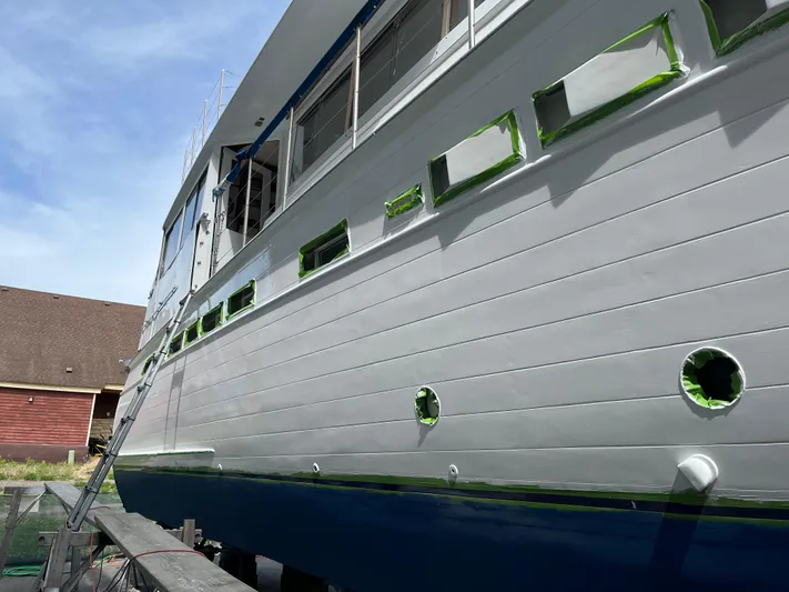  Yacht Photos Pics 1966 Chris-Craft 57 Constellation yacht undergoing maintenance with taped windows and fresh paint.