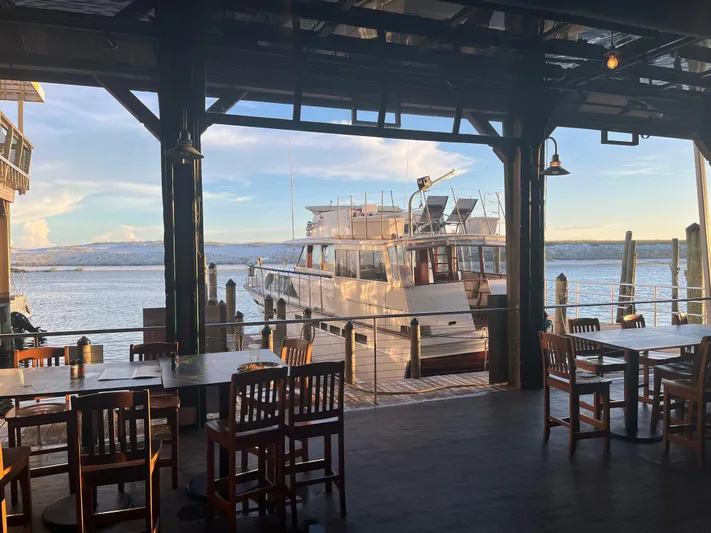  Yacht Photos Pics 1966 Chris-Craft 57 Constellation yacht docked near waterfront dining area.
