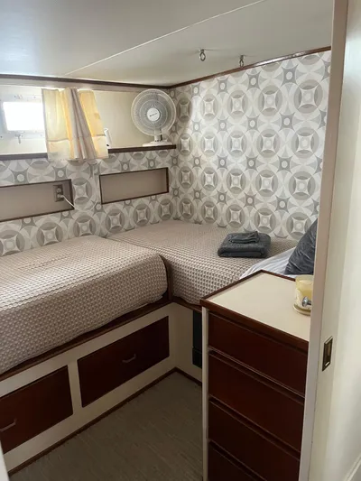  Yacht Photos Pics 1966 Chris-Craft 57 Constellation cabin with twin beds, retro wallpaper, and a small fan.