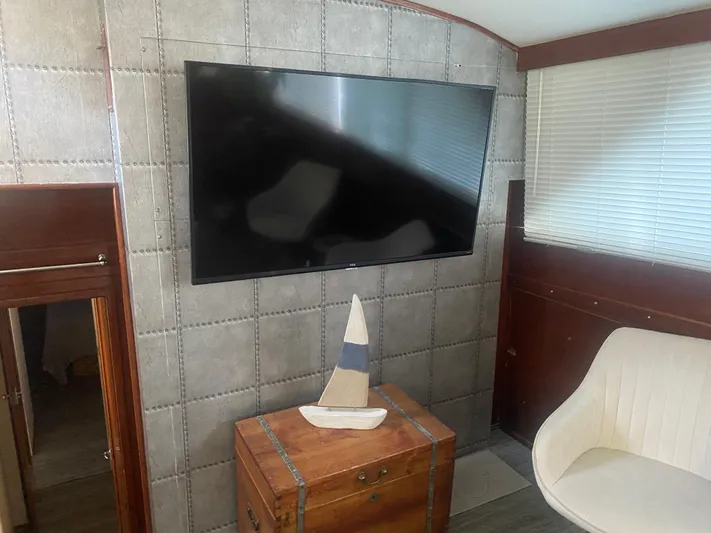  Yacht Photos Pics Interior of 1966 Chris-Craft 57 Constellation with TV, chair, and decorative sailboat.