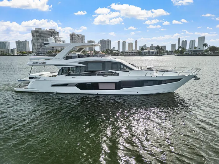 Live More Yacht Photos Pics 2021 Galeon 680 Fly yacht cruising on water with city skyline in background.