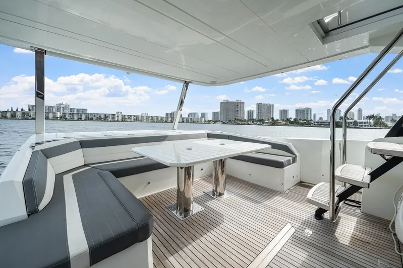 Live More Yacht Photos Pics Luxurious 2021 Galeon 680 Fly yacht deck with seating, table, and waterfront city view.