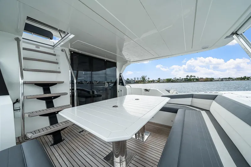 Live More Yacht Photos Pics Luxurious 2021 Galeon 680 Fly yacht deck with seating and table, overlooking serene waters.