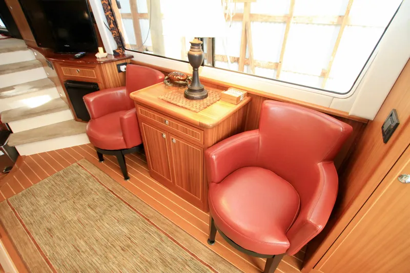  Yacht Photos Pics Luxurious interior of 2011 Fathom Element 43 yacht with red leather chairs and wooden cabinetry.