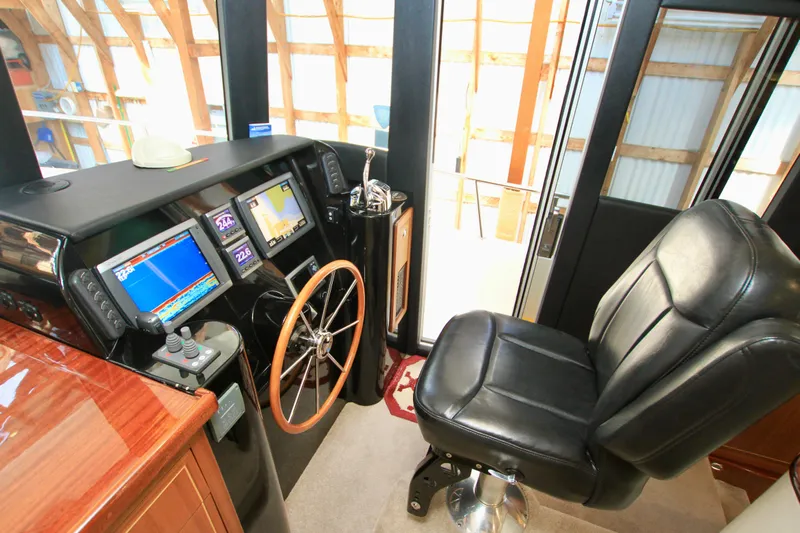  Yacht Photos Pics Pilot seat and control panel of 2011 Fathom Element 43 boat, featuring navigation screens and steering wheel.