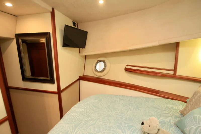  Yacht Photos Pics Cozy cabin interior of 2011 Fathom Element 43 yacht with bed, TV, and porthole.