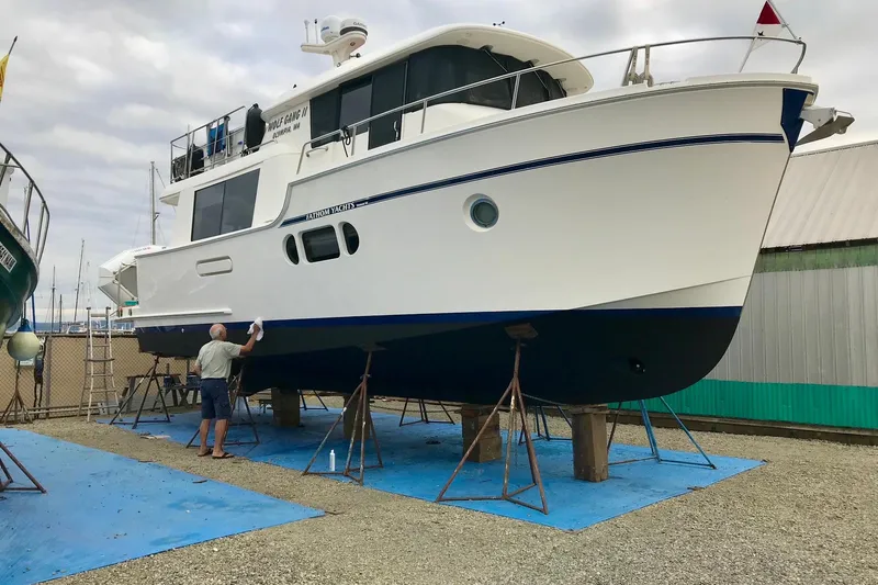 Yacht Photos Pics Man cleaning a 2011 Fathom Element 43 yacht on stands in a boatyard.