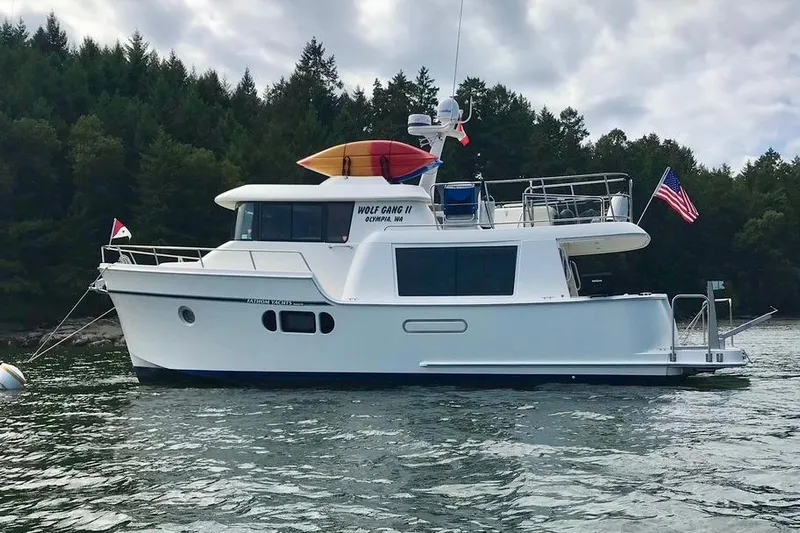  Yacht Photos Pics 2011 Fathom Element 43 yacht on water, forested background, flags displayed.