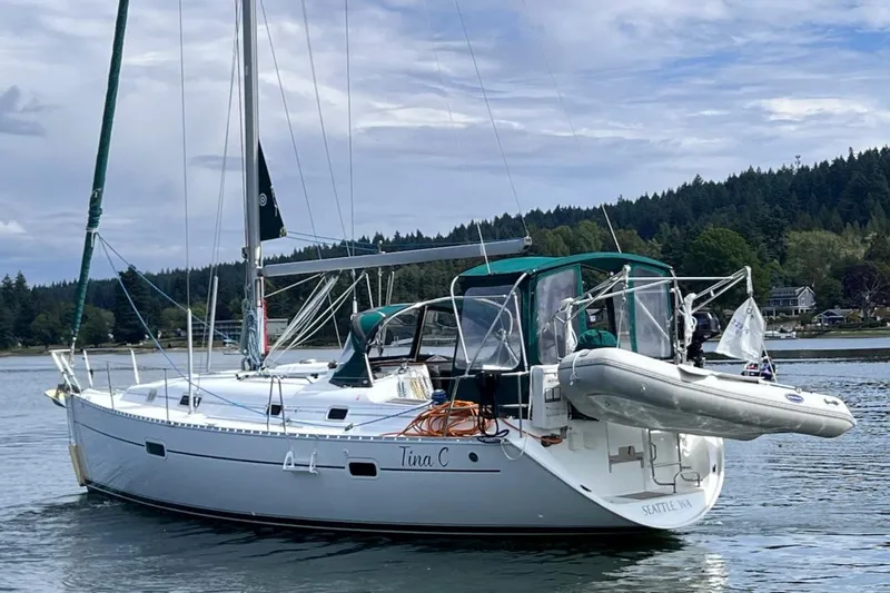 Tina C Yacht Photos Pics 2001 Beneteau 361 sailboat on water, with forested shoreline in background.