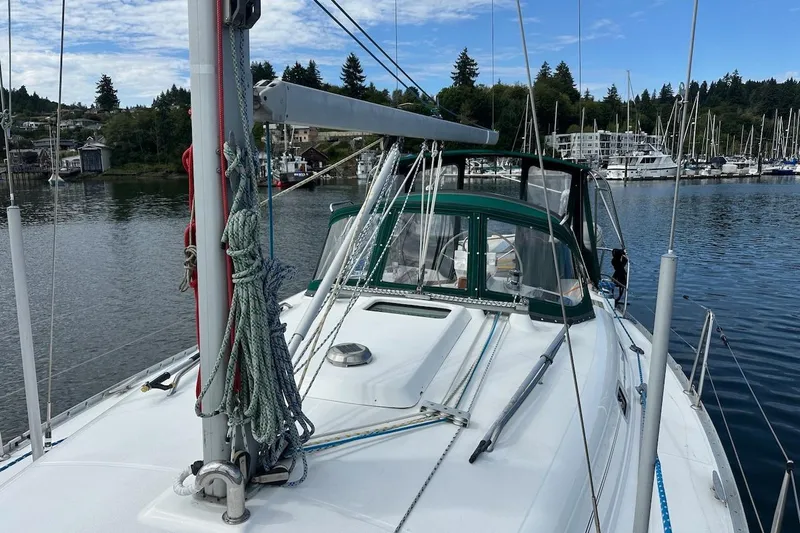 Tina C Yacht Photos Pics 2001 Beneteau 361 sailboat docked in a marina, surrounded by water and trees.