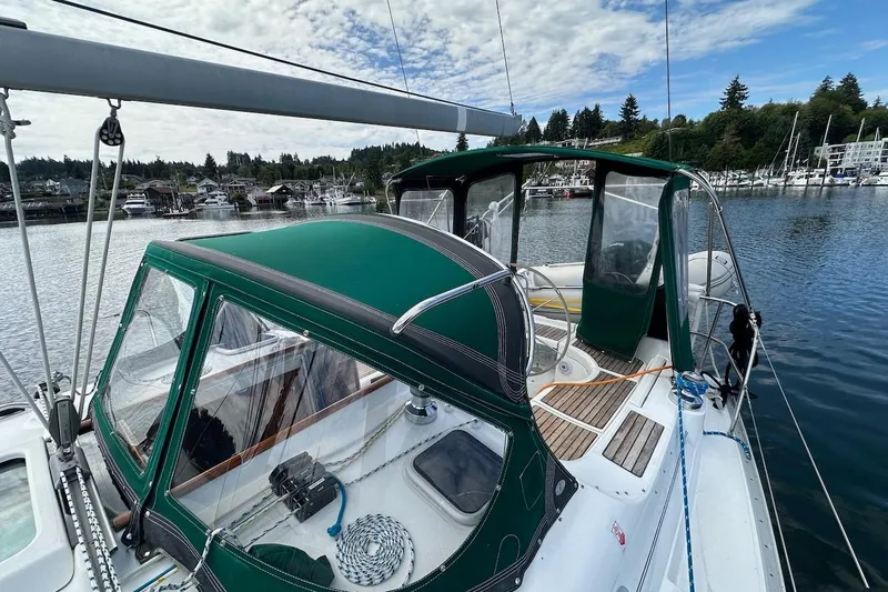 Tina C Yacht Photos Pics 2001 Beneteau 361 sailboat with green canopy docked in a scenic marina.